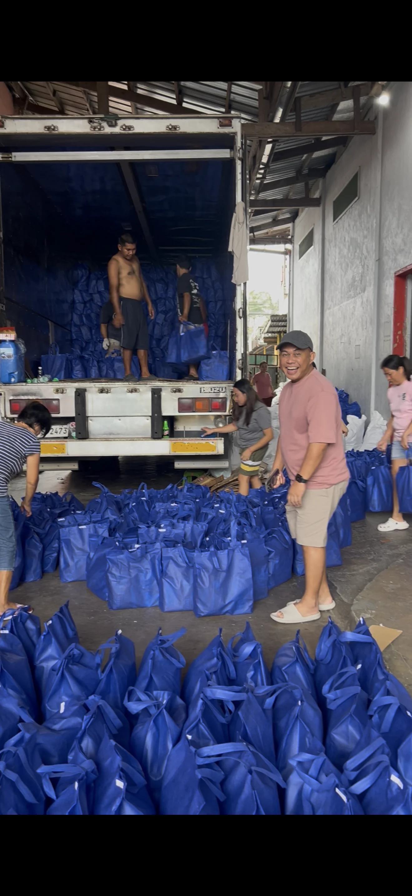 Team and prepared grocery packages beside the delivery truck